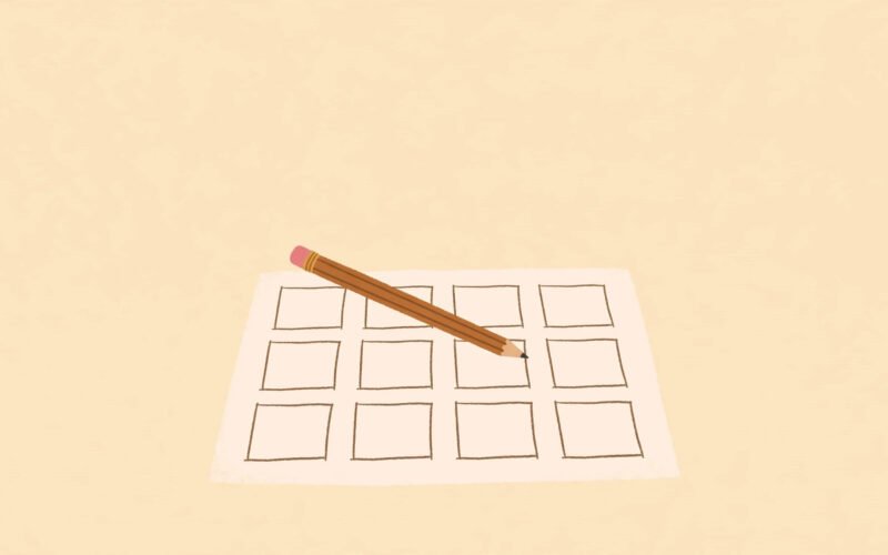 A pencil resting on a blank sheet of paper with a hand-drawn grid, on a warm plain background.